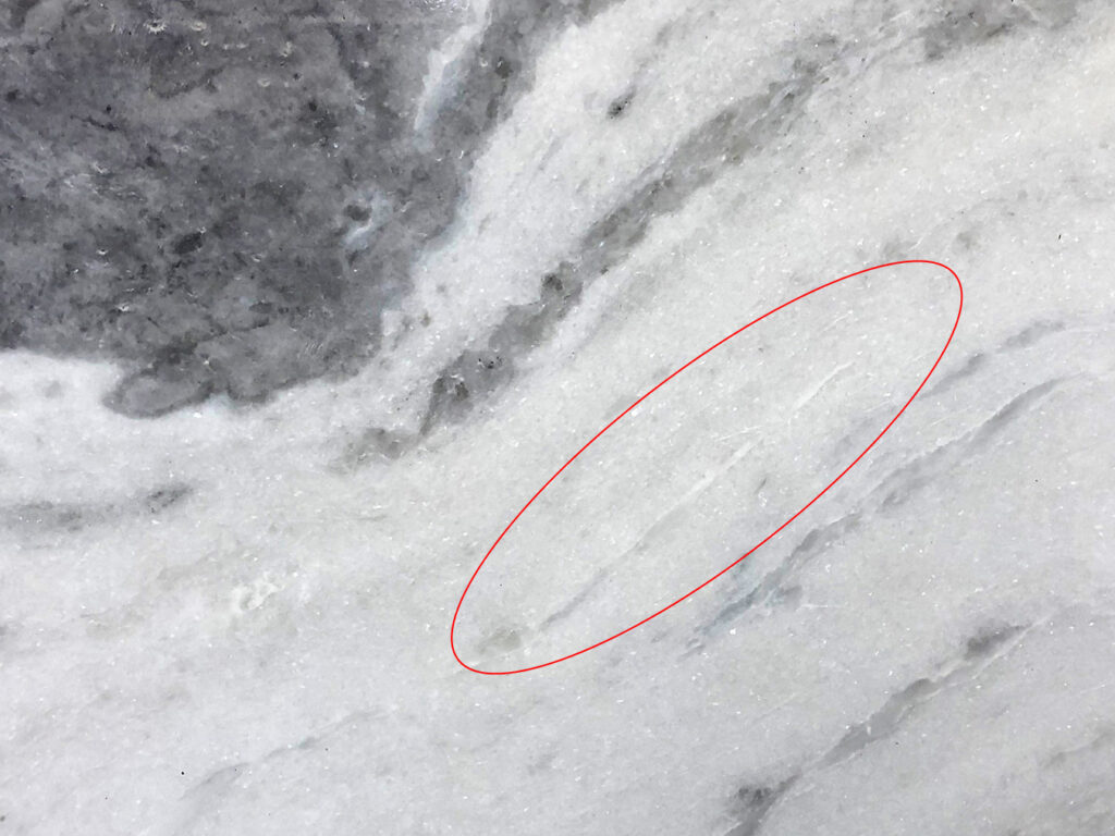 Photograph of a piece of polished veined white marble.