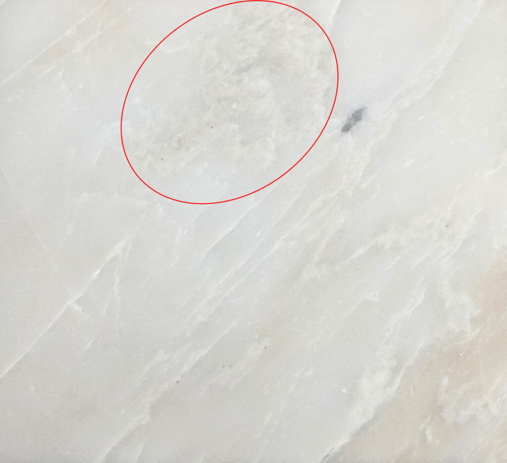 Photograph of a piece of polished veined white marble.