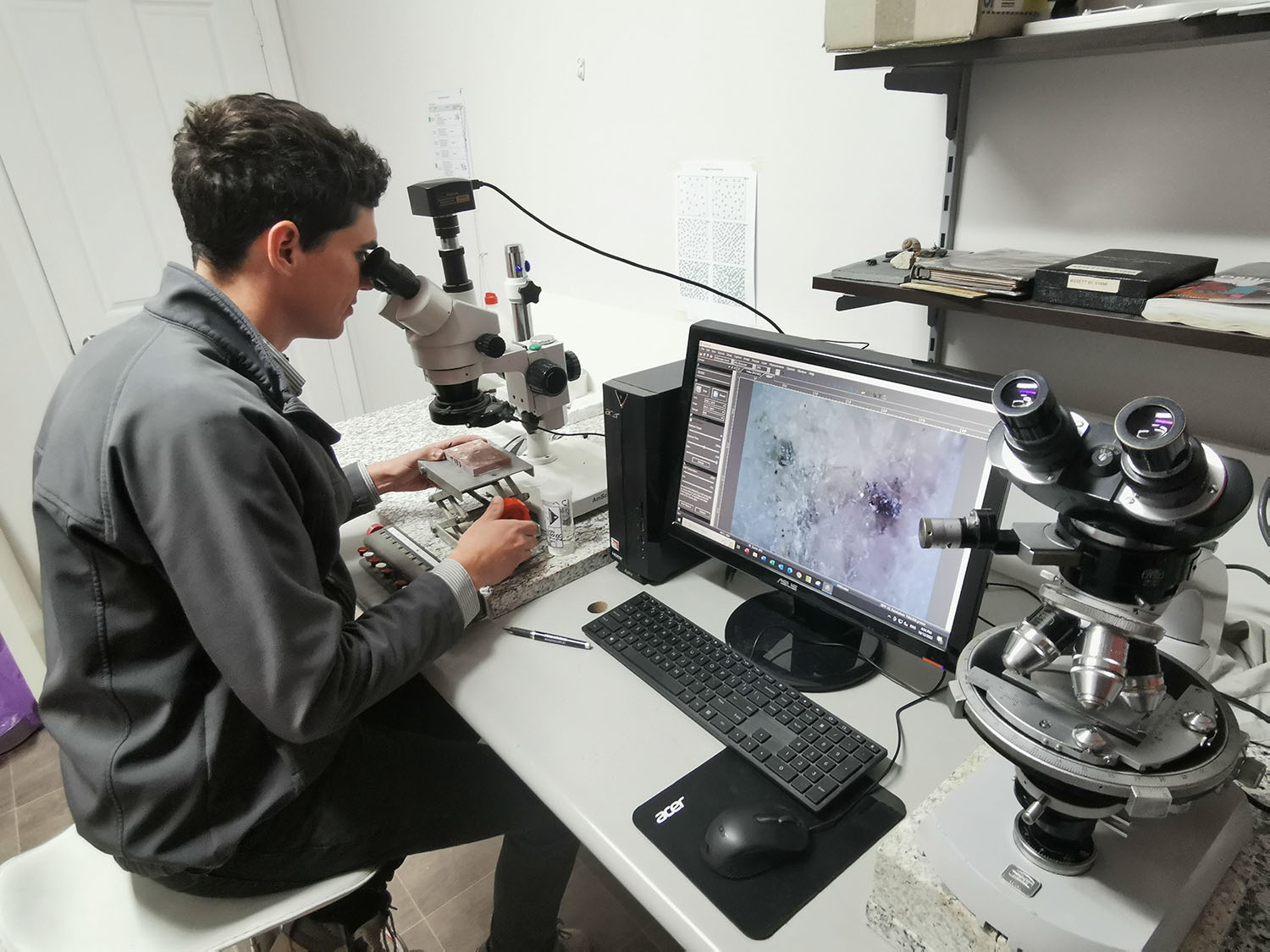 Specialist technician looking through microscope for petrographic analysis