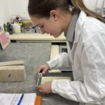Image of technician measuring stone sample in lab setting