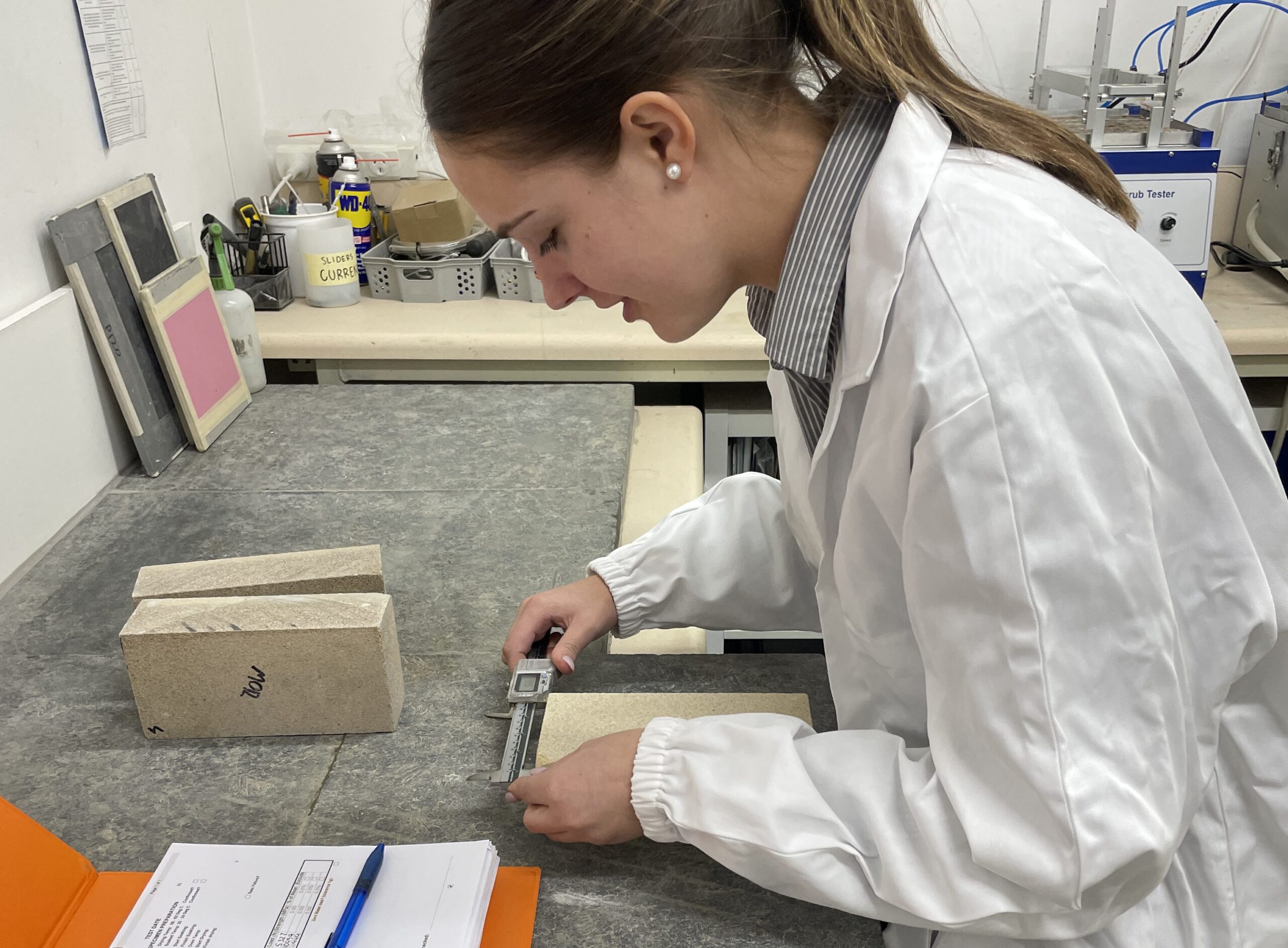 Image of technician measuring stone sample in lab setting