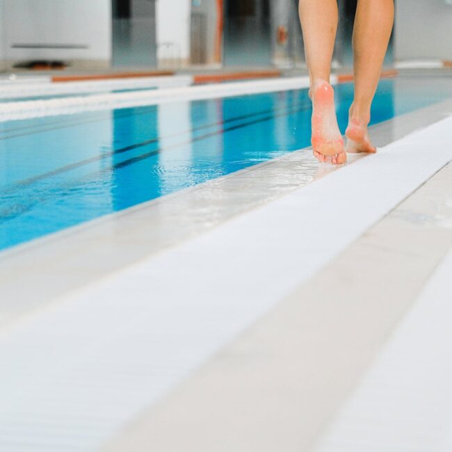 feet of a person walking in the poolside